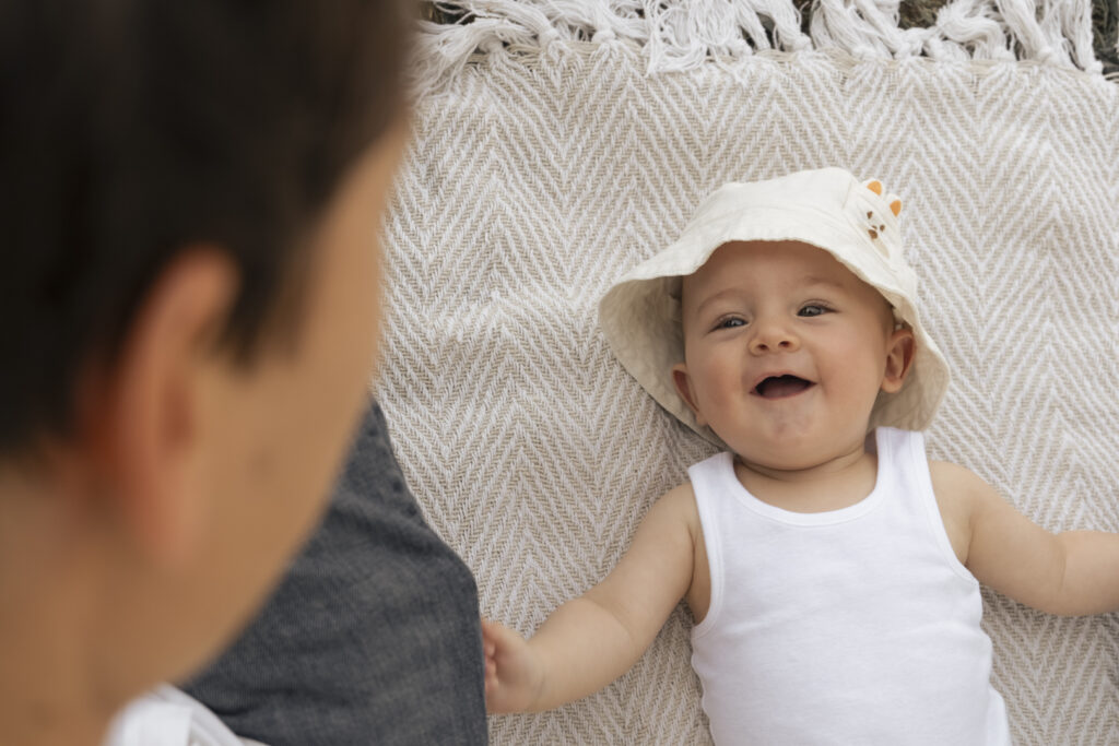 Portrait tendre d’un bébé souriant, réalisé par Claire Stroh, photographe spécialisée en enfance à Souffelweyersheim